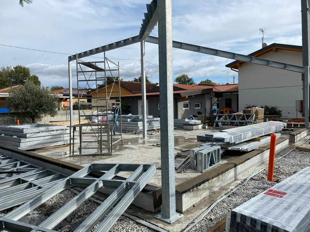 Fotografia del cantiere di una residenza privata: pilastri, travi in acciaio ed elementi di parete da montare